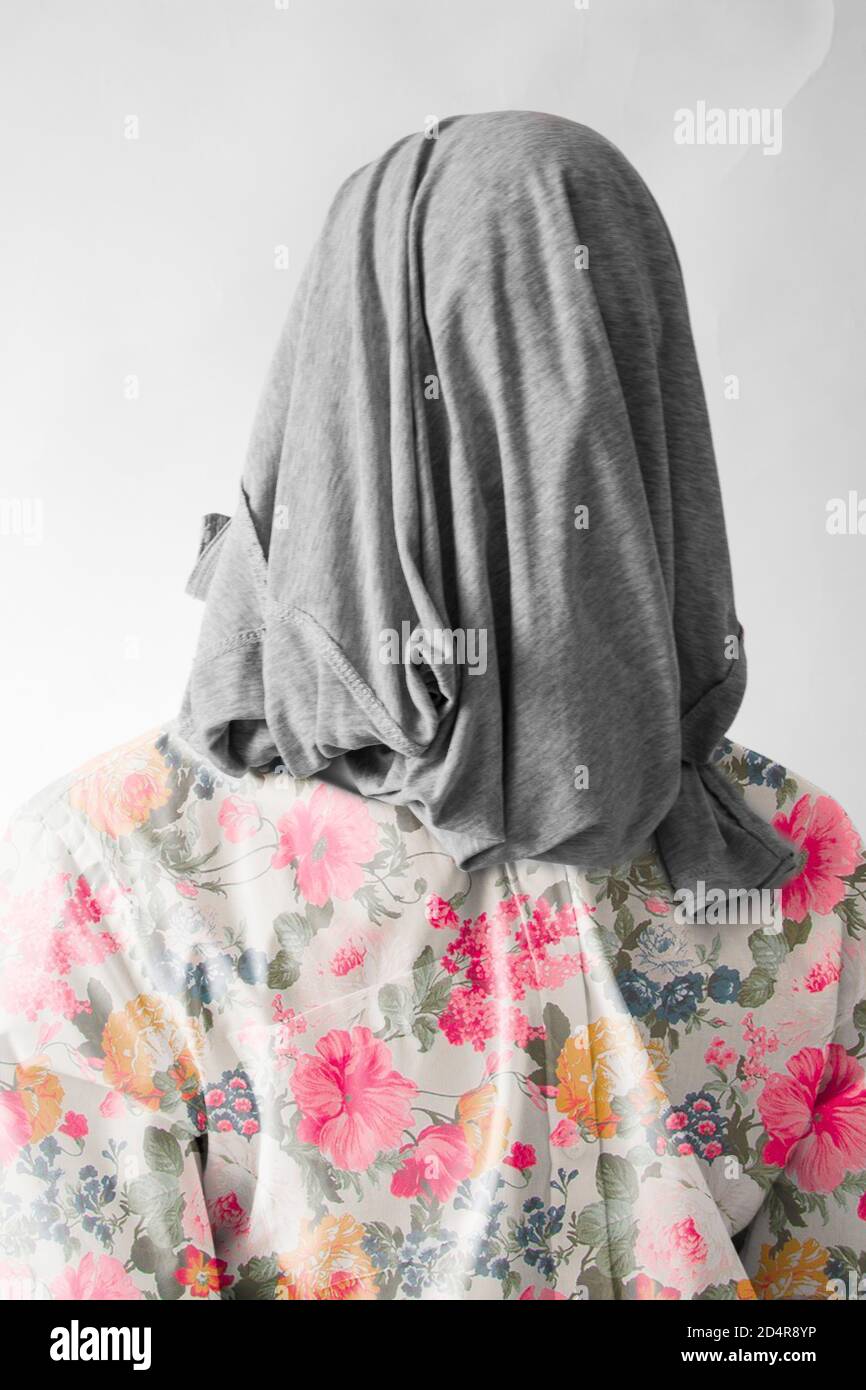 man without identity dressed in a floral shirt and a gray cloth covering his face with a white background. Stock Photo