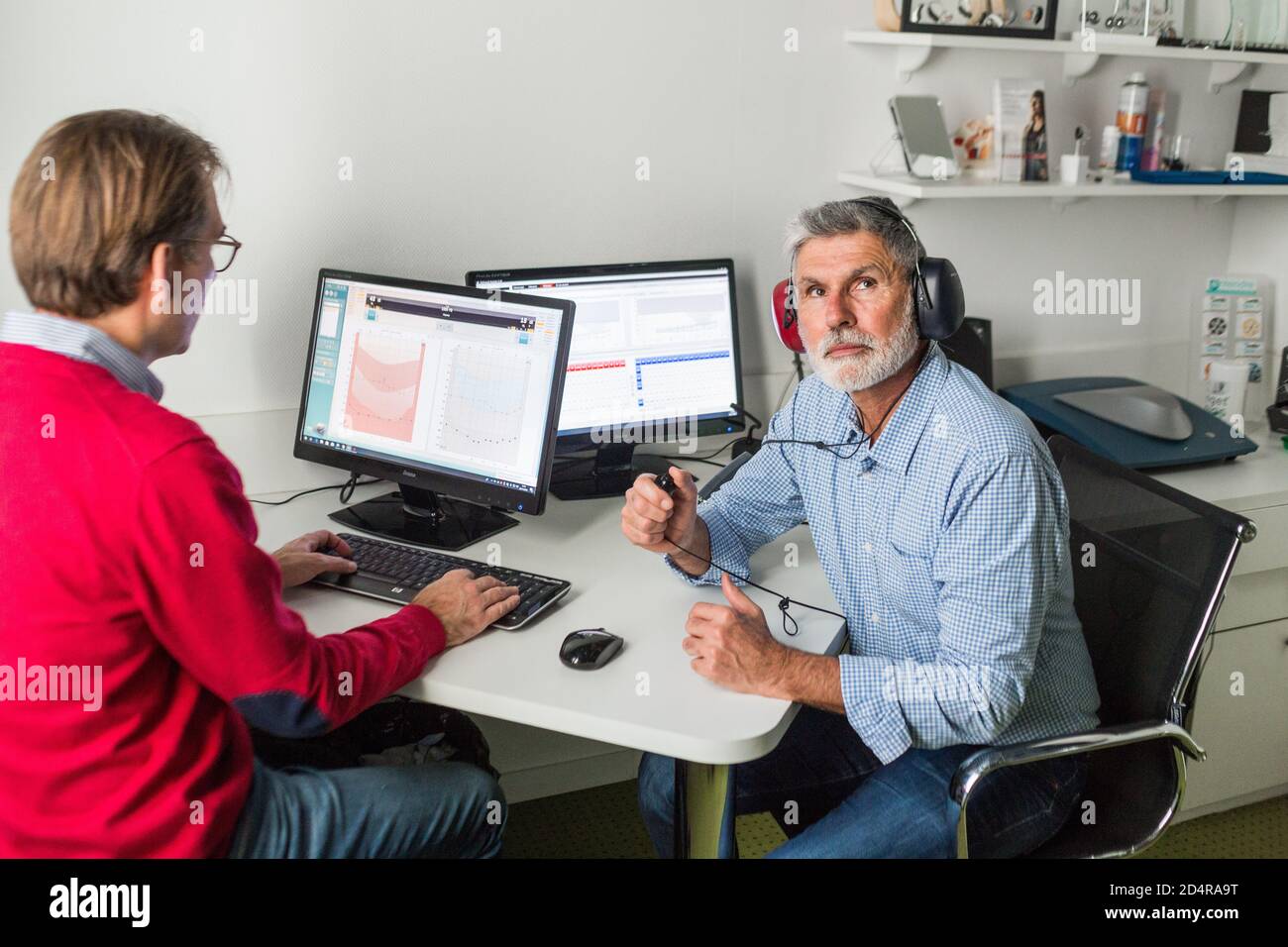 Man undergoing pure-tone audiometry test and hearing threshold measurement. Stock Photo