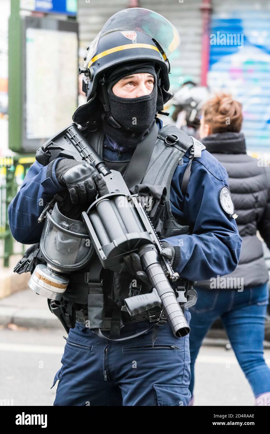 CRS utilisant un LBD 40 ( lanceur de balles de défense, flash ball ) lors d'une manifestation de gilets jaunes à Paris. Stock Photo