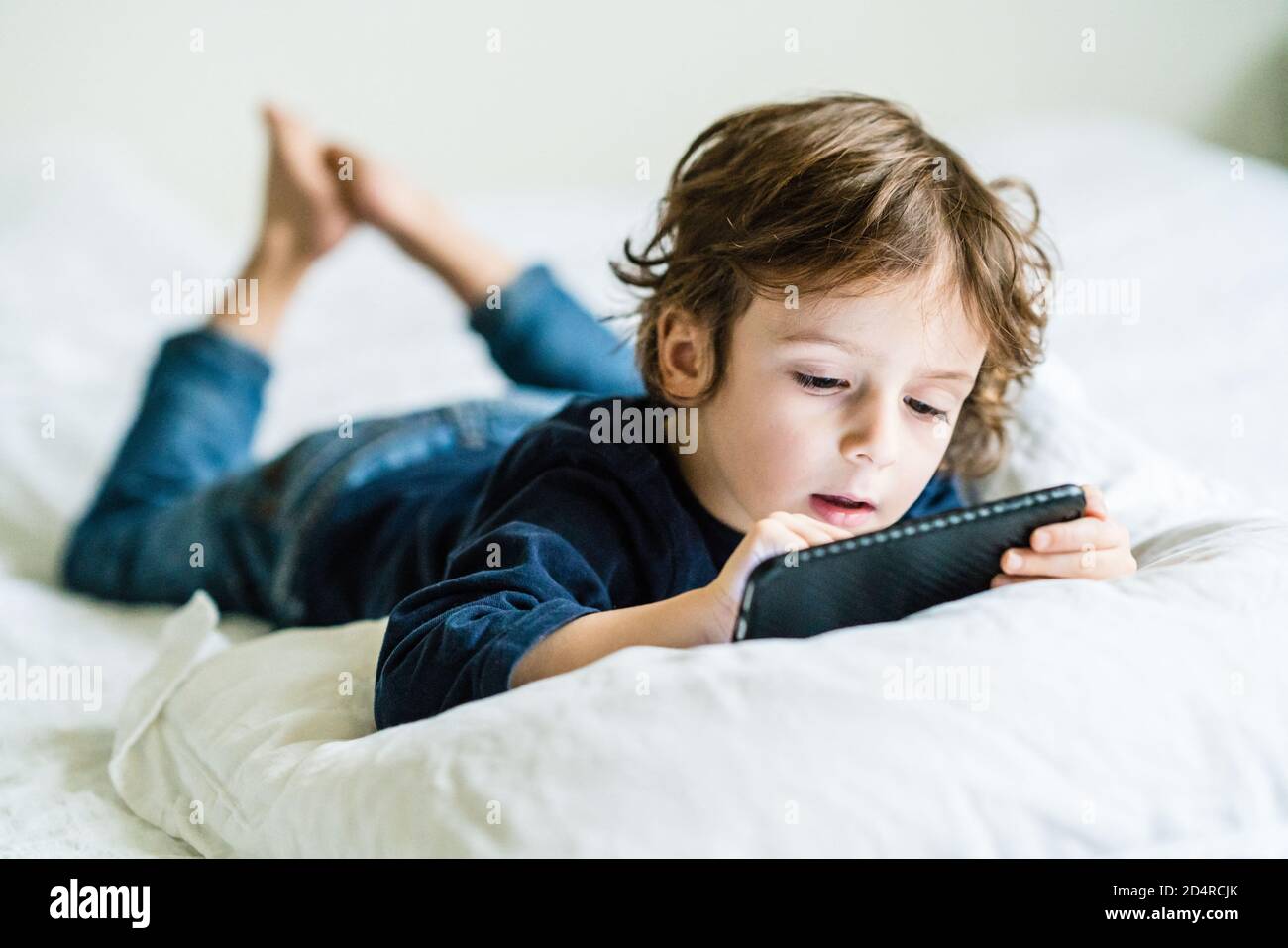 4 year old boy playing with a smartphone. Stock Photo