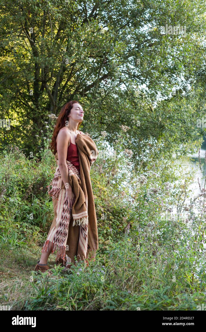 Woman at the edge of a river. Stock Photo