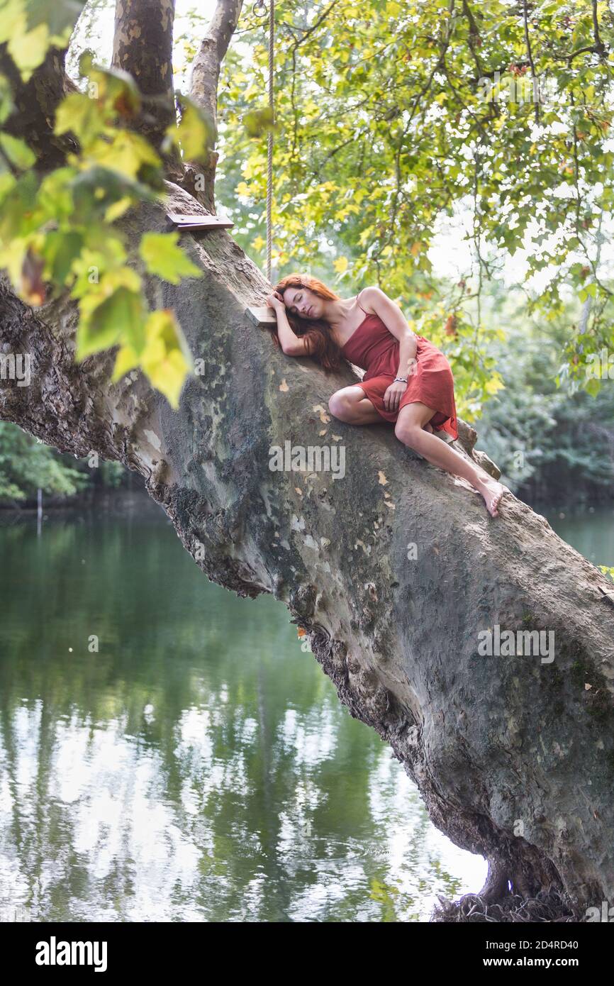 Woman lying on a tree trunk. Stock Photo
