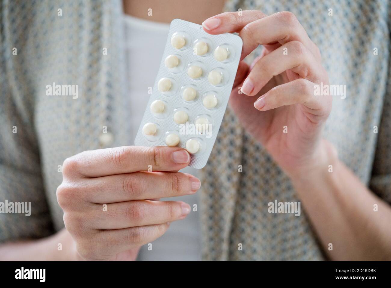 Woman taking an hormone replacement therapy pills. Stock Photo