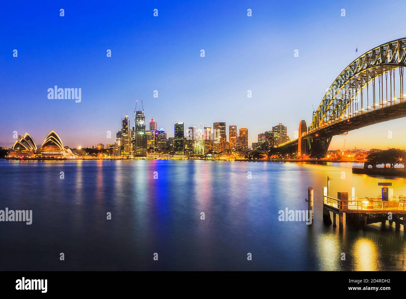 Kirribilli whart on Sydney harbour at sunset in view of city CBD waterfront and the Bridge. Stock Photo