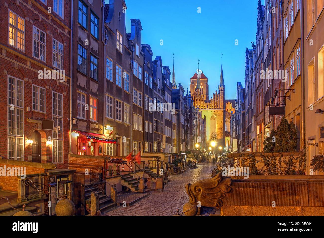 Night scene along the historical Mariacka Street in Gdansk, Poland towered by the St Mary Church (Basilica of the Assumption of the Blessed Virgin Mar Stock Photo