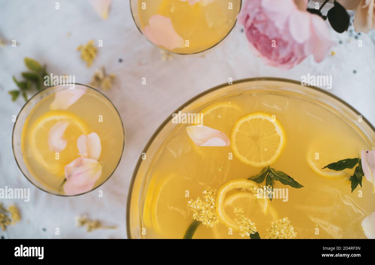 Lemon punch bowl with two glasses and flowers in summer Stock Photo