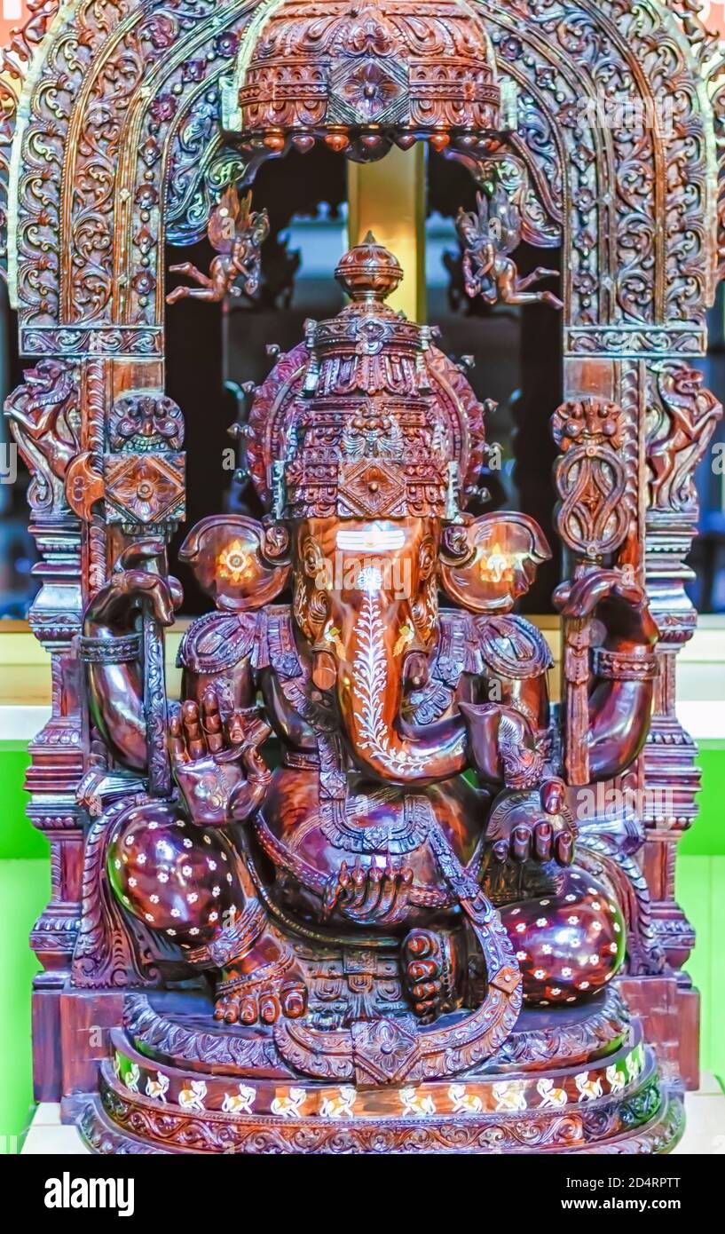 An intricately carved wooden statue of Lord Ganesha. Stock Photo