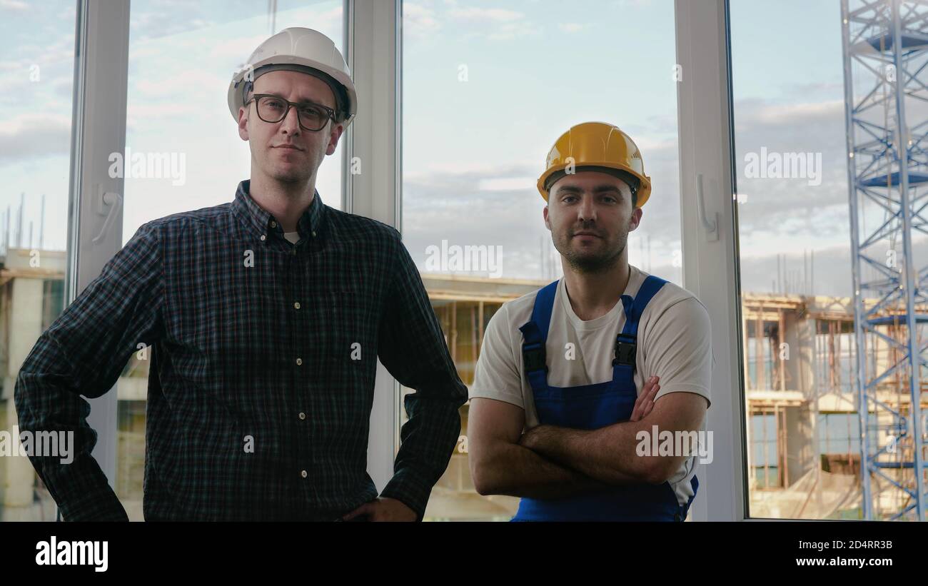 Builders working team looking to camera at construction site. Stock Photo