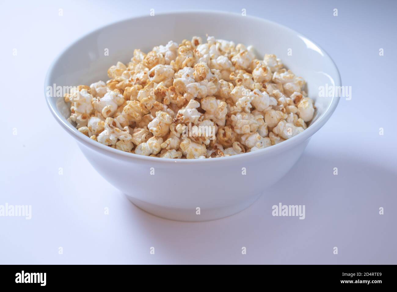 White bowl with popcorn on white background Stock Photo