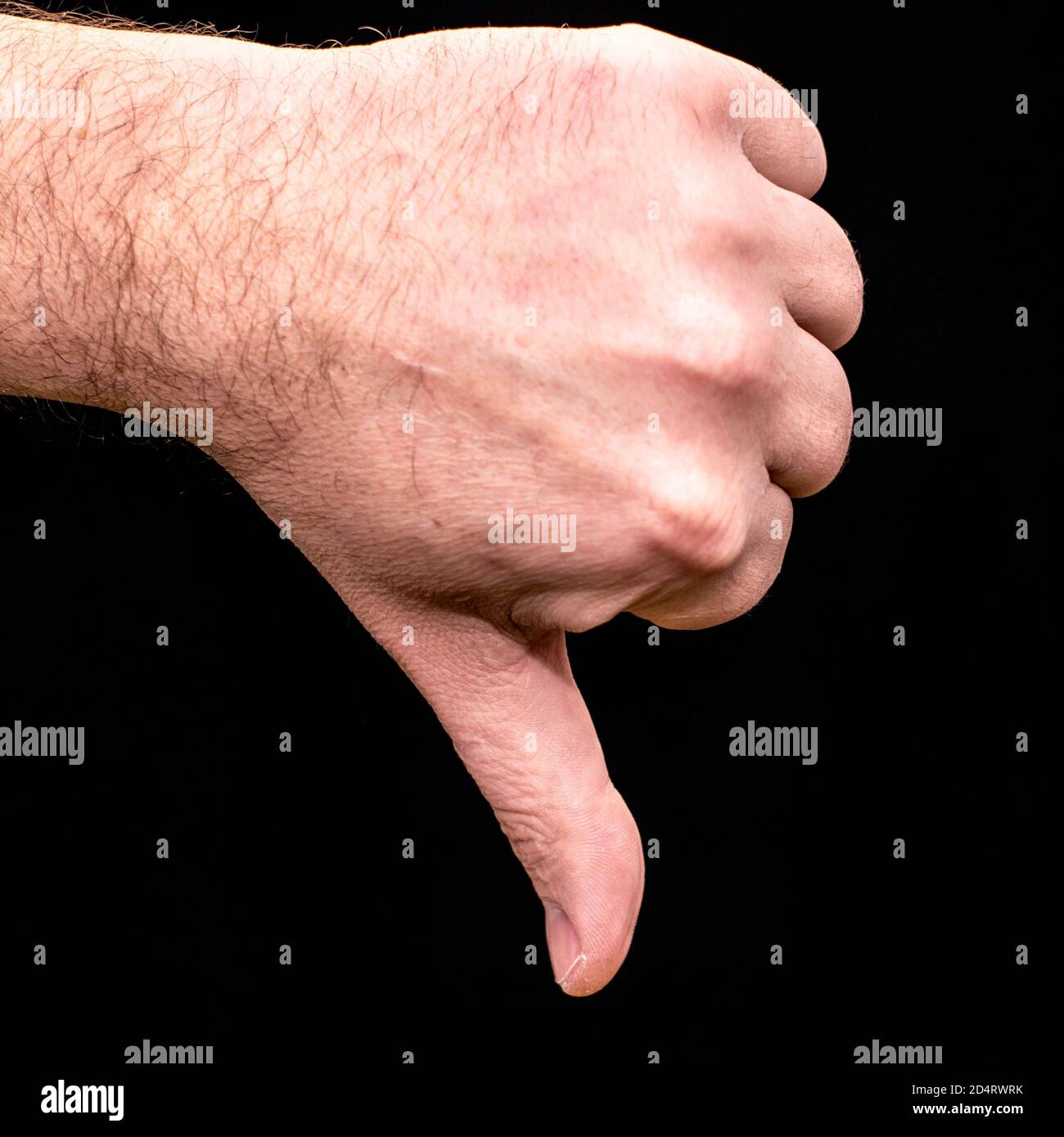 male palm clenched into a fist thumb pointing down on a black