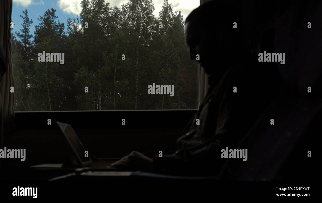 Disappointed man working on a tablet in a train. Stock Photo