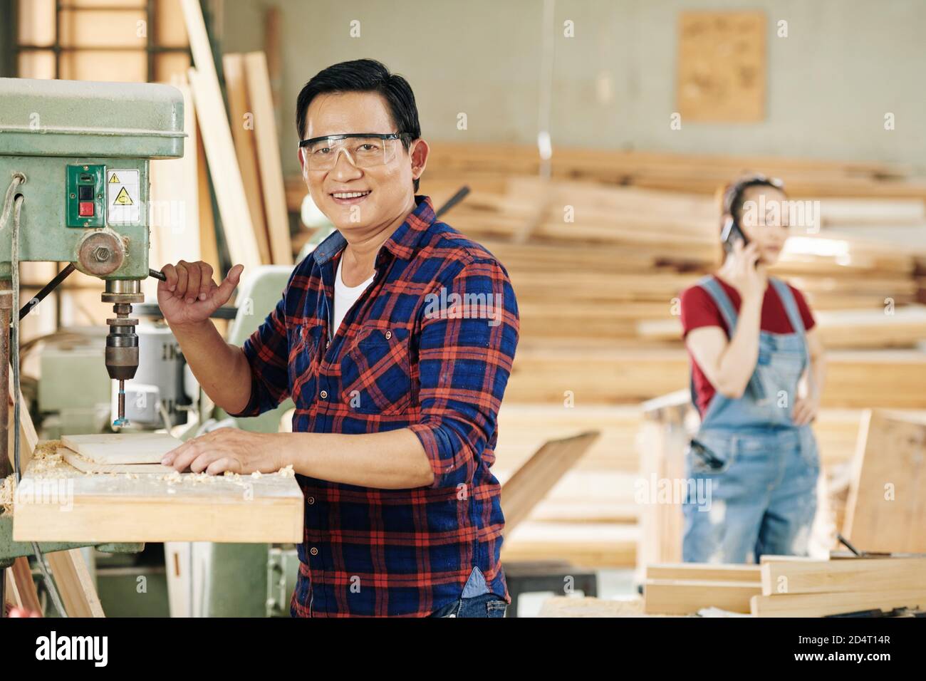 Carpenter drilling holes in plank Stock Photo