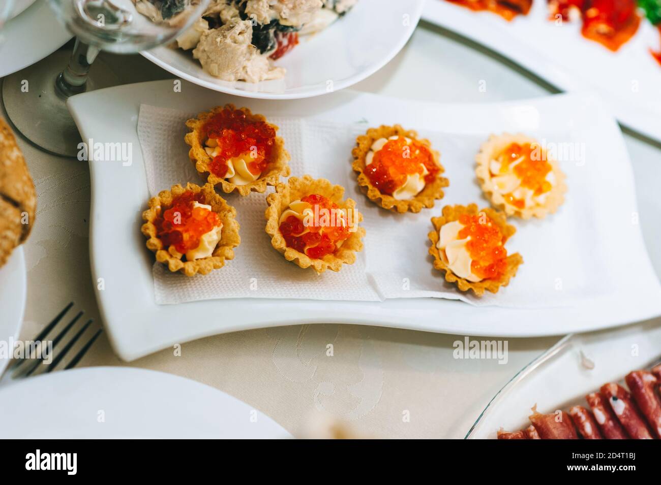 Close up of appetizing tartlets with caviar on a white plate. Stock Photo