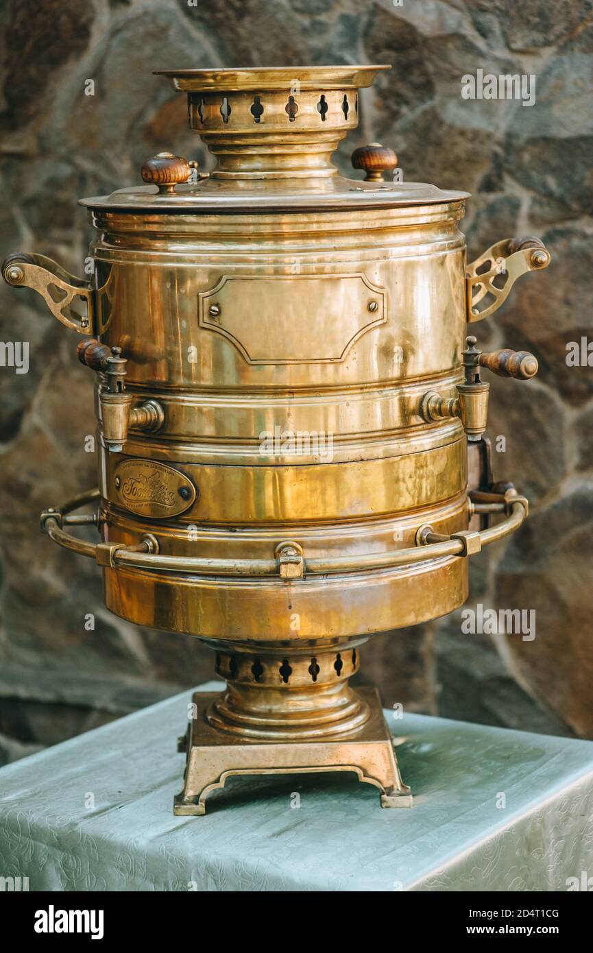 Ancient golden brass large samovarstanding on the table outdoors. Stock Photo