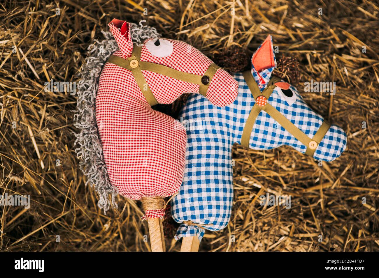 Two retro cotton fabric horse toy on a stick lying on the hay. Vintage