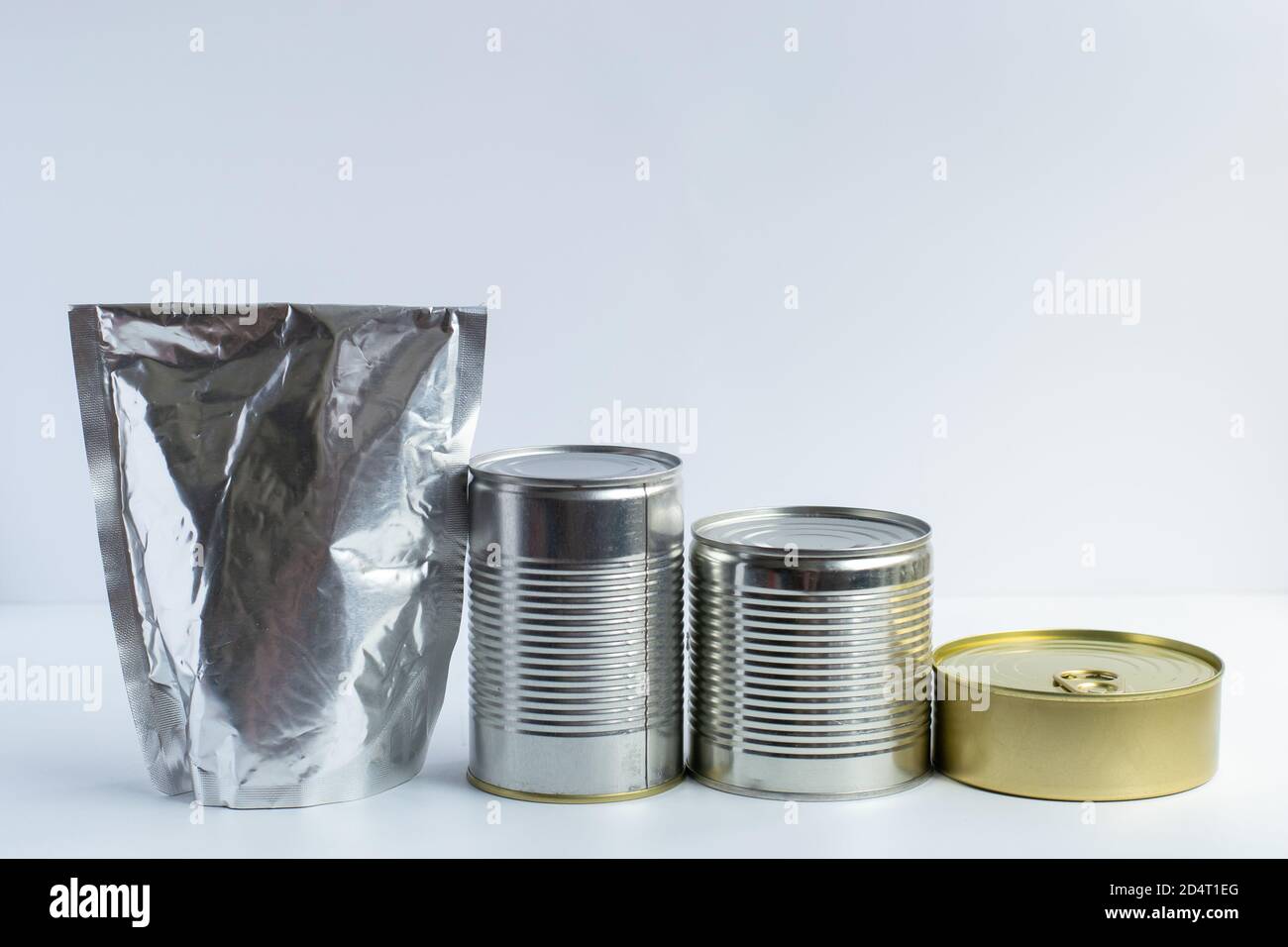Metal cans of different sizes, metallized flexible packet on a white