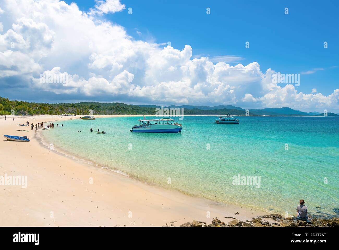 Whitsundays, Queensland, Australia - A group of people on the beach admiring the view and taking pictures at the Whitsunday Island. Stock Photo
