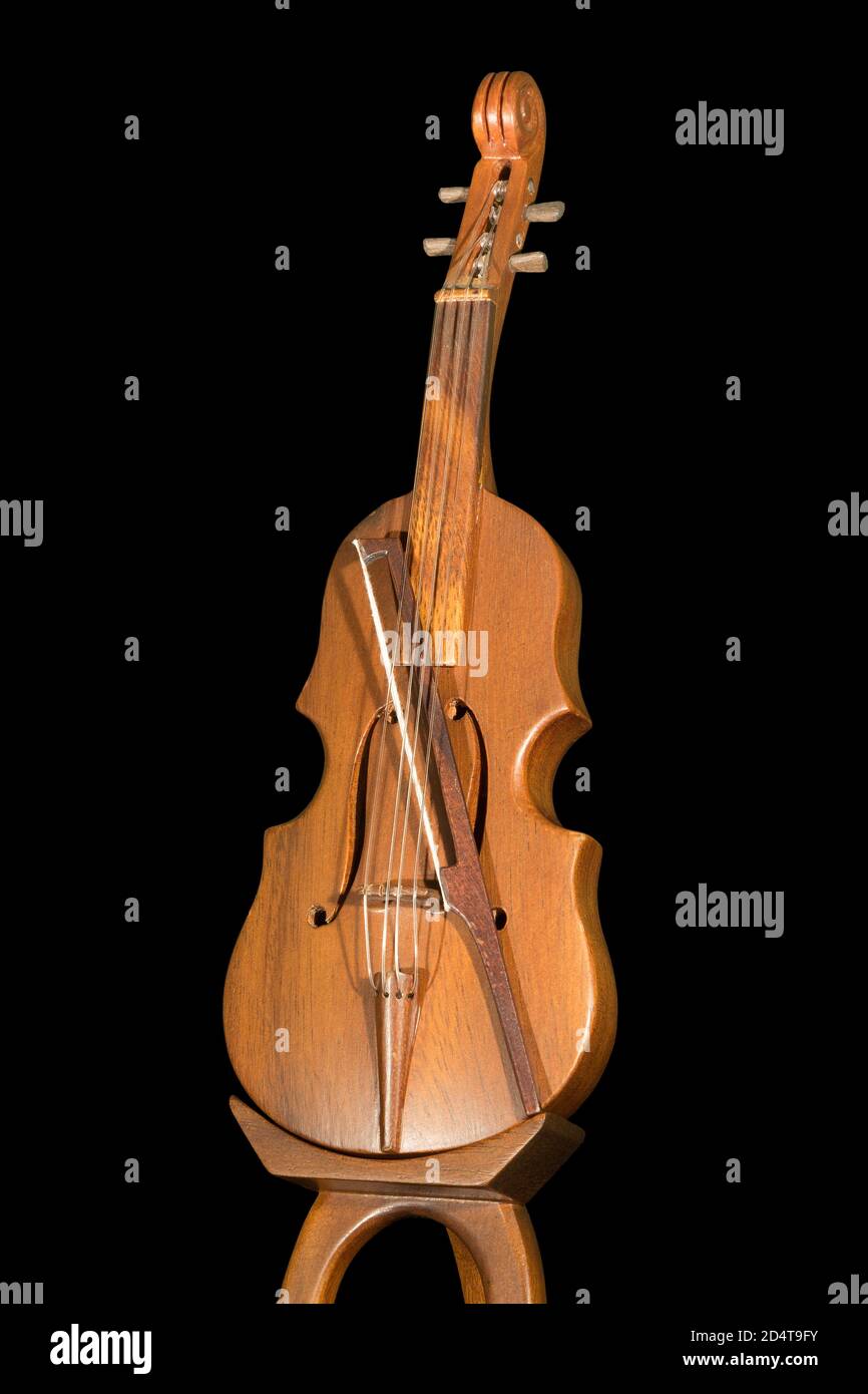 A wooden model of a violin with a bow, isolated on a black background Stock Photo