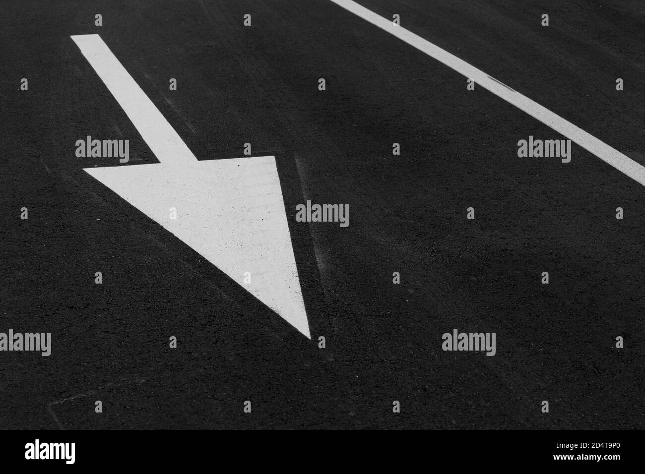 white arrow on asphalt to define direction Stock Photo