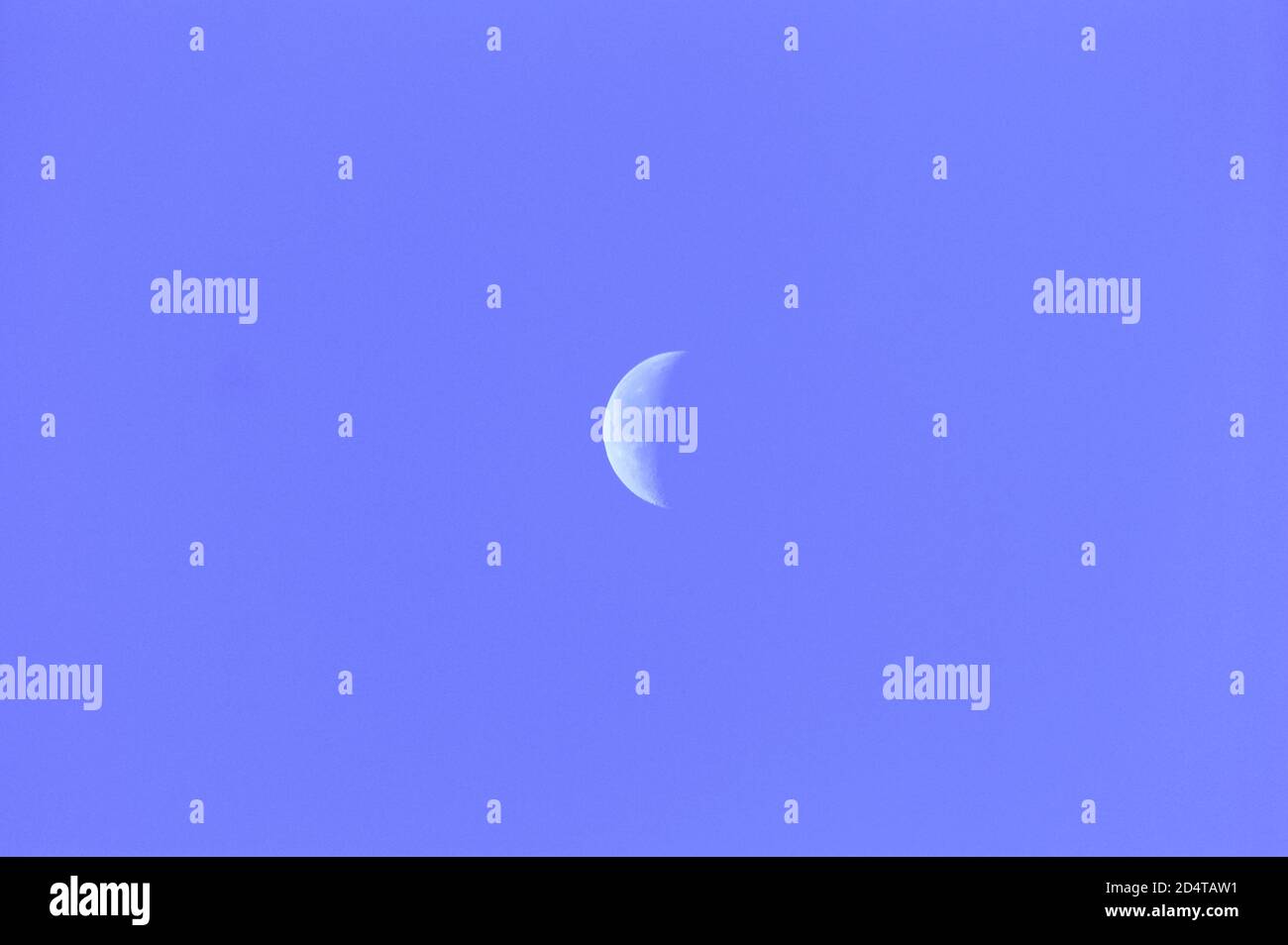Clear blue sky with waning moon Stock Photo
