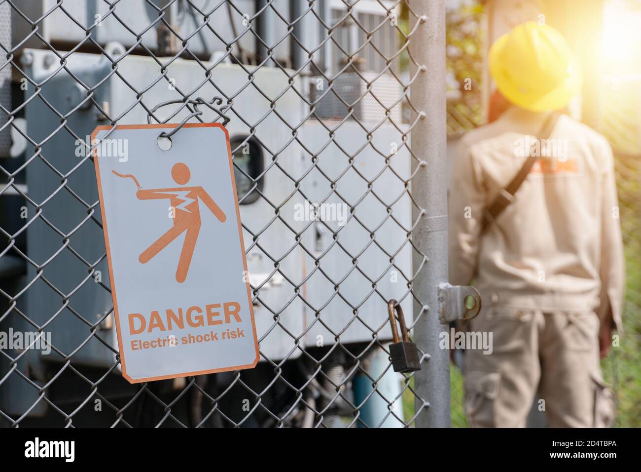 Warning sign of electric shock danger Hanging on a metal mesh fence