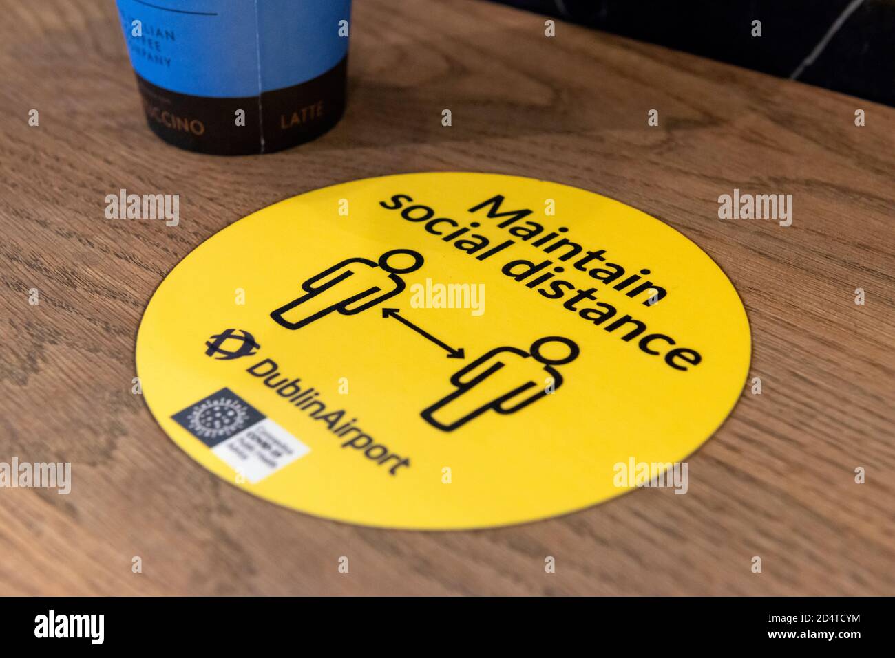 Covid Ireland and maintain social distancing yellow sign due to Covid 19 pandemic in coffee shop or cafe at the Dublin Airport Ireland Europe Stock Photo