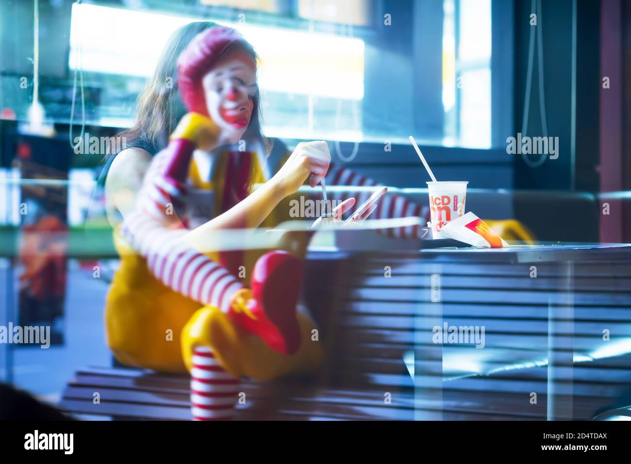 Bangkok, Thailand - JULY 9, 2019: A Ronald McDonald statue and Asian woman reflection on the mirror of the McDonald’s fast-food restaurant. Bangkok. Stock Photo