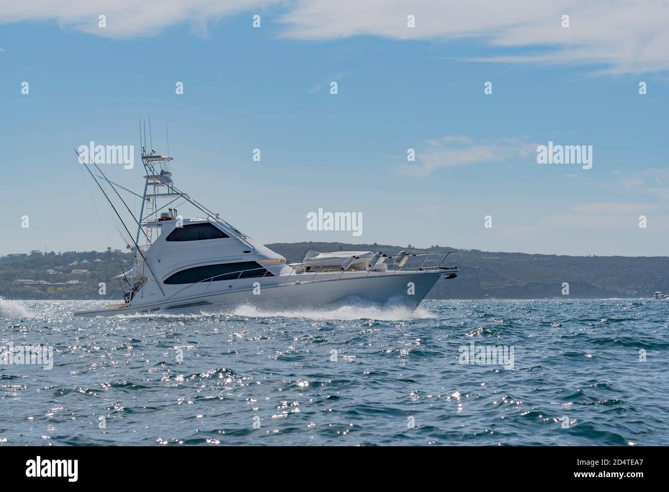 A salt water deep sea fishing charter boat in slightly choppy water on Sydney Harbour, Australia Stock Photo