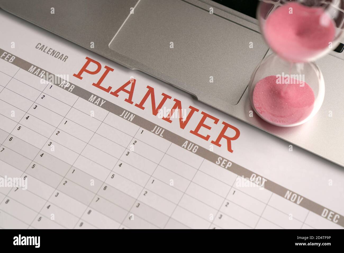 Hourglass on top of computer laptop and calendar planner. Business planning concept. Stock Photo