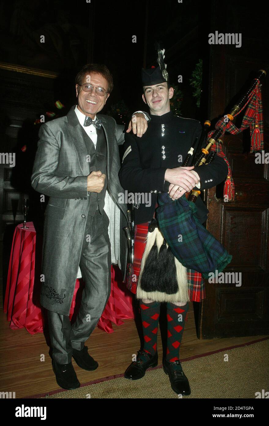 Cliff Richard's Tennis Foundation Dinner at Hampton Court 11th Dec 2003: Cliff Richard with a Scottish piper Stock Photo