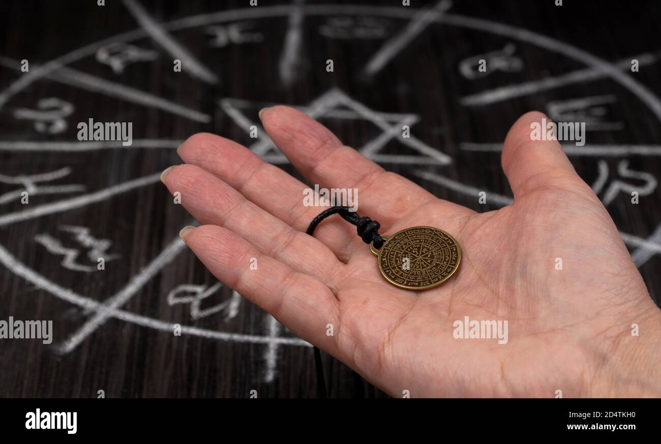 amulet of predictions in the palm of your hand on the background of magic.  Stock Photo