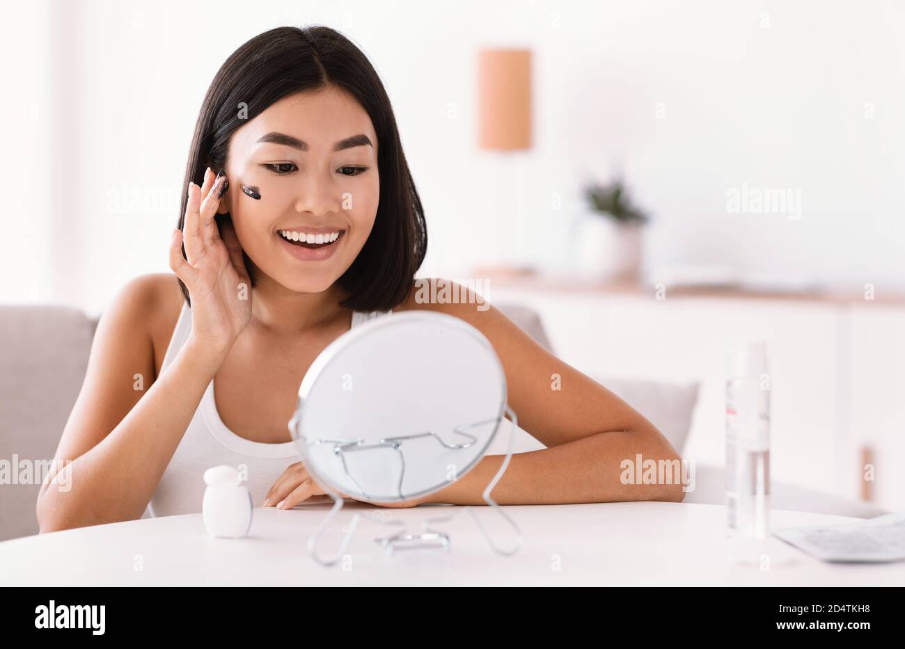 Portrait of asian woman cleaning her face with scrub Stock Photo