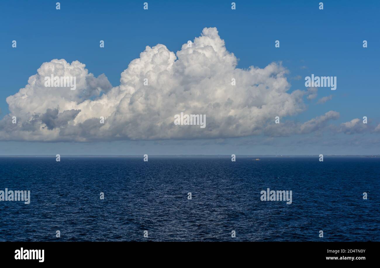 White cumulus clouds in sky over blue Baltic sea Stock Photo - Alamy
