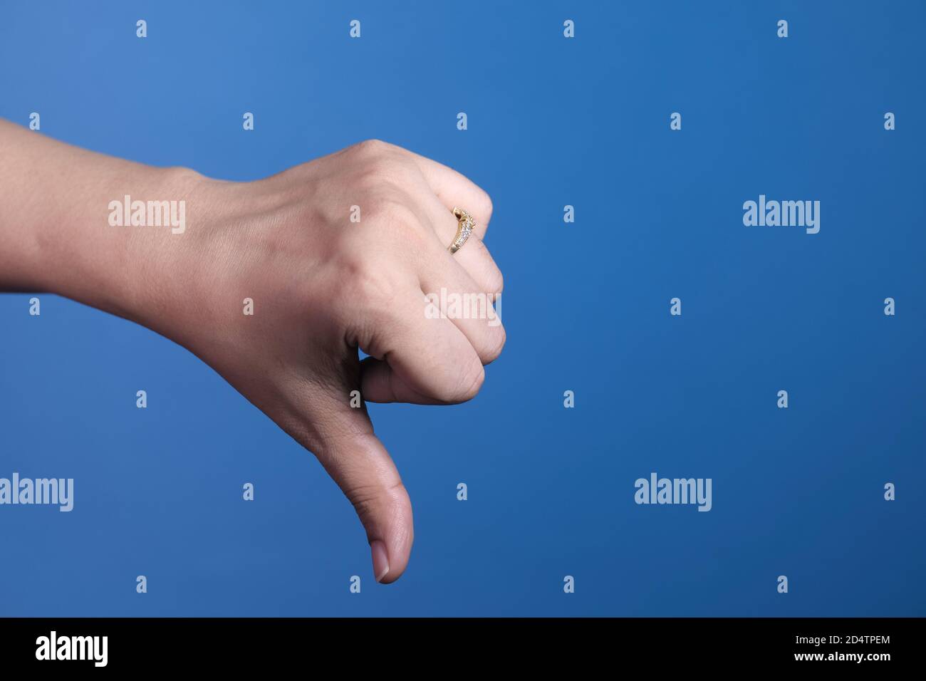 hand showing thumb down sign on blue background Stock Photo - Alamy