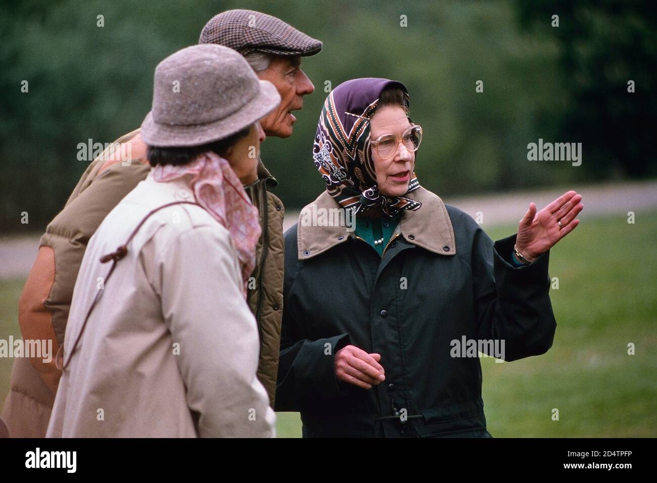 Queen Elizabeth II, wearing a headscarf and green waxed jacket, in conversation at the Royal Windsor Horse Show. 13 May 1989 Stock Photo