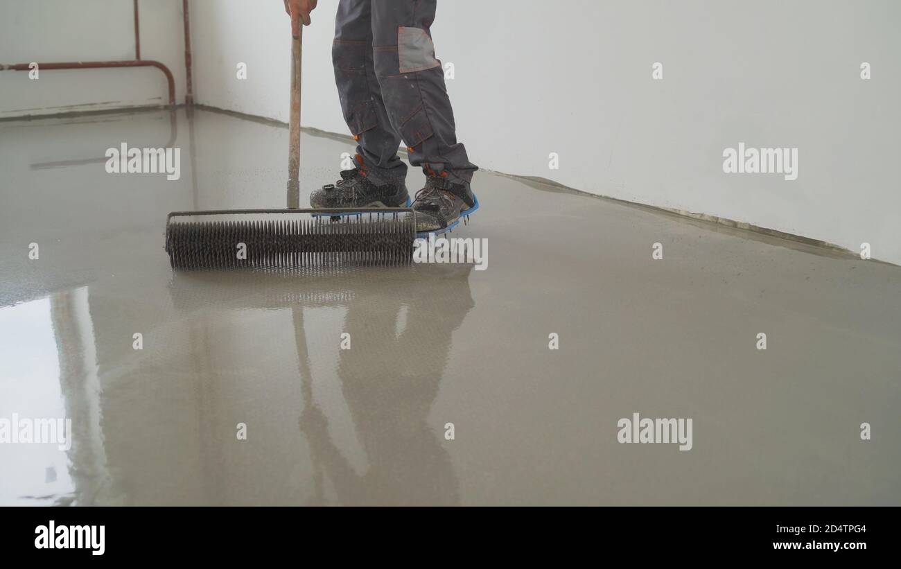 The process of laying the selfleveling floor. Compaction of dry cement