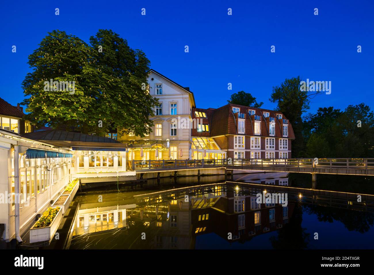 Old restaurant and hotel at the Ilmenau River in the old town of Lueneburg, Germany with night blue sky and clean reflection. Stock Photo