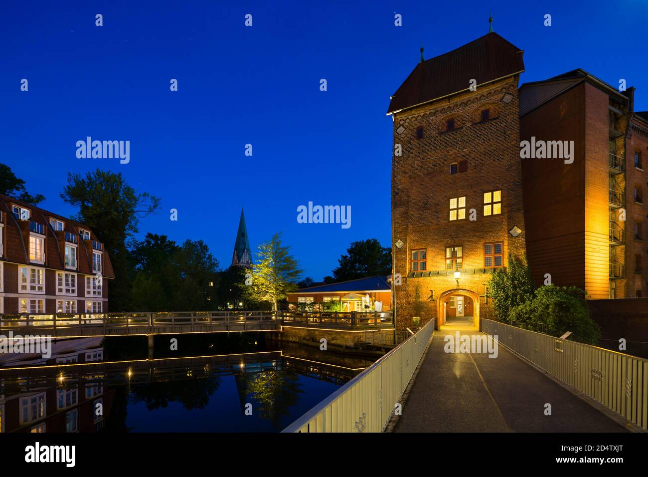 Bridge and old tower at the Ilmenau River in the old town of Lueneburg, Germany with night blue sky. Stock Photo