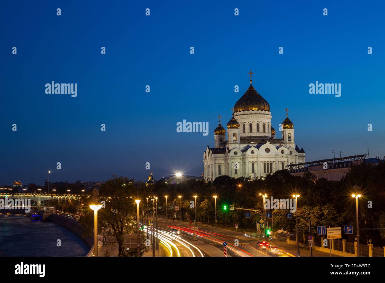 Cathedral of Christ the Savior in Moscow against the background of the night sky and a street, which is lit by lanterns. The temple is located on the Stock Photo