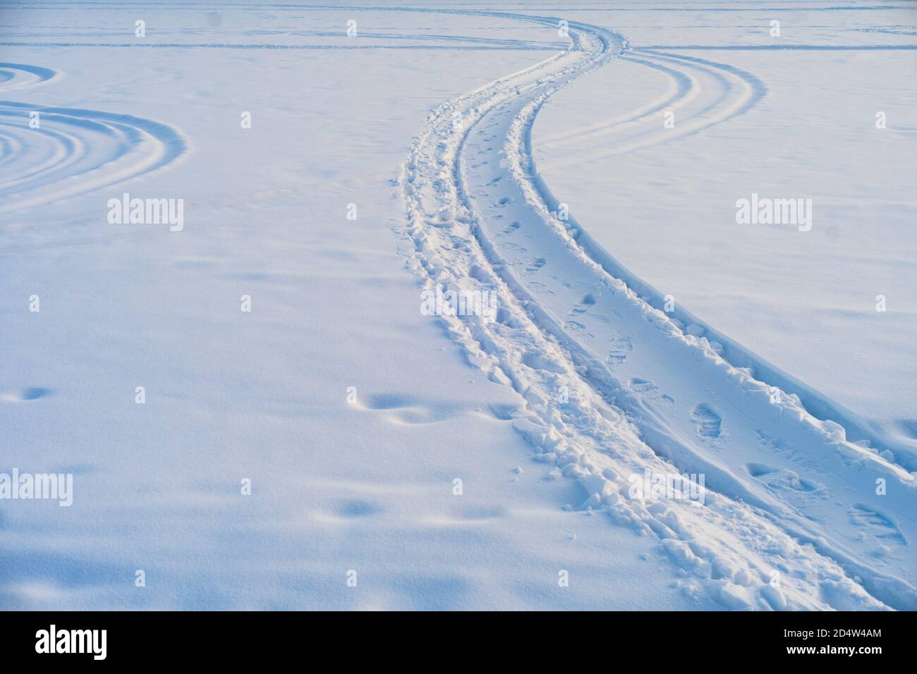 Snowmobile and people left footprints in the snow on a winter day. Stock Photo