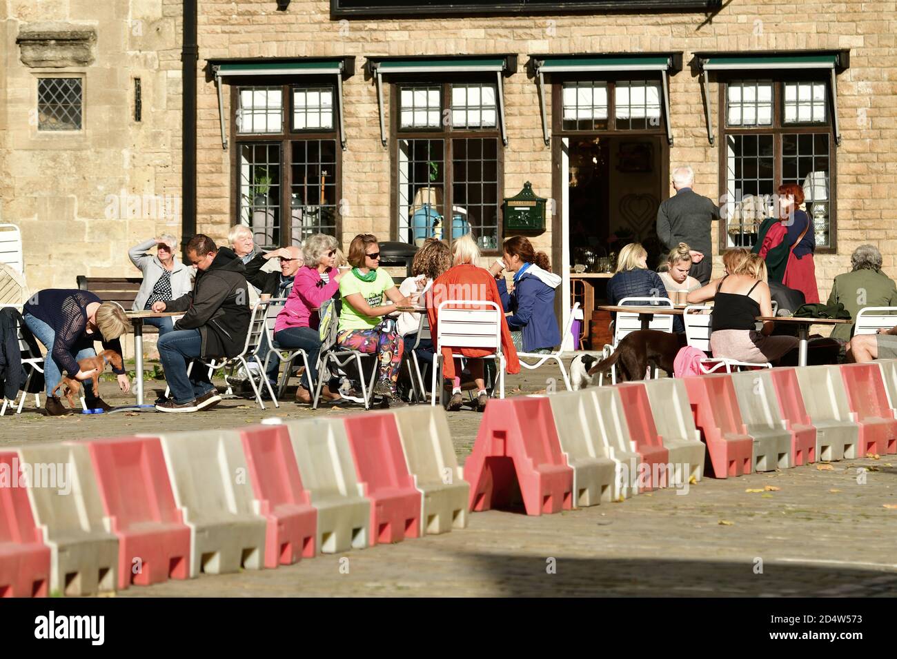 Wells, UK. 11th Oct, 2020. 11/October 2020. The New Normal, covid-19 eating out with red and white barriers separating people for social distancing at the City of Wells in Somerset on a warm and mild afternoon in October. Picture Credit: Robert Timoney/Alamy Live News Stock Photo