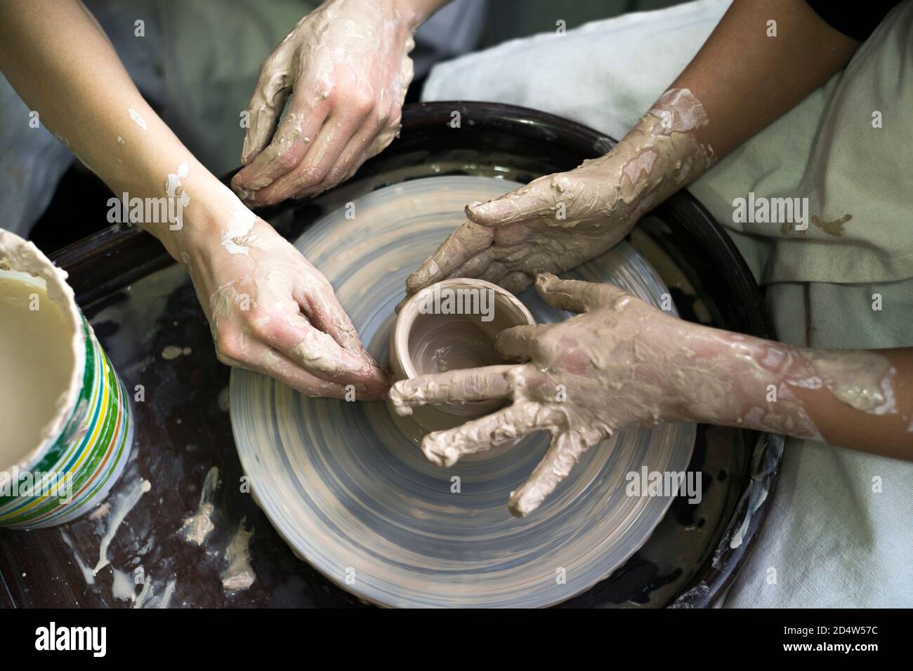 Pottery wheel. Pottery workshop. A potter sculpts a clay pot on a potter's  wheel. Vector illustration. Stock Vector