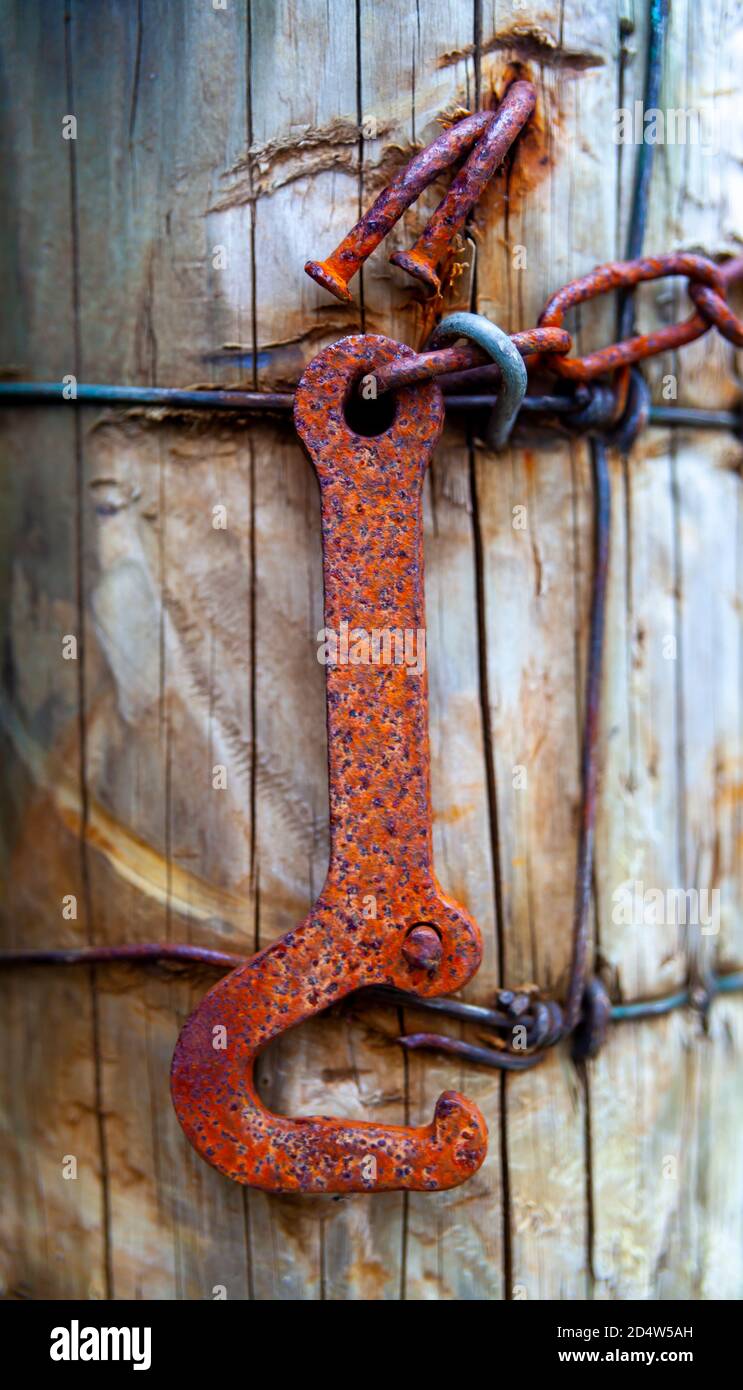wooden post with barbed wire and rusty spanner, close up and macro Stock Photo