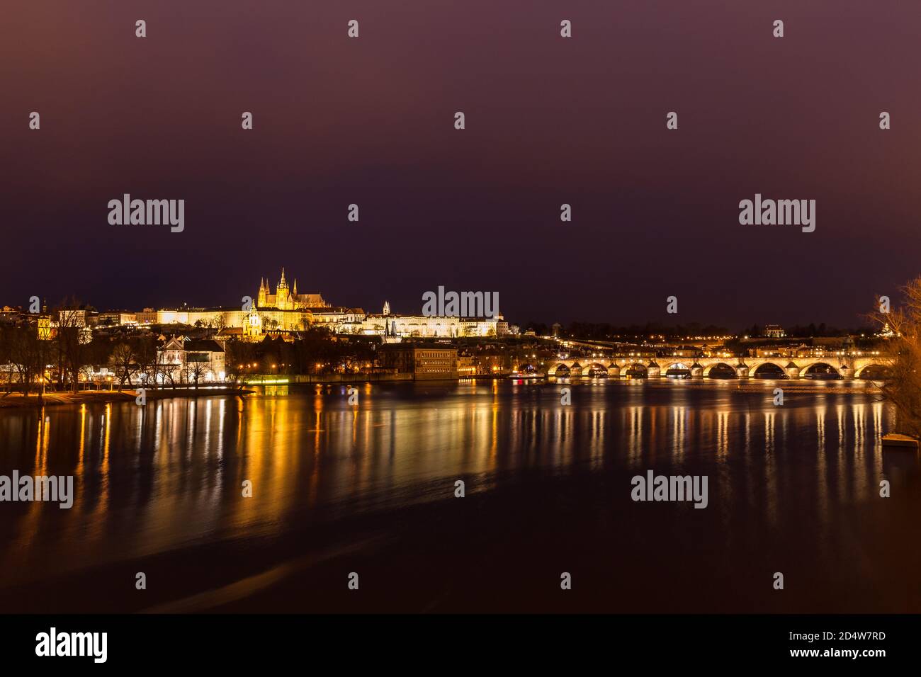 Panorama night view of the light illuminated Prague Castle and St. Vitus Cathedral with Charles Bridge over Vltava River and in the center of old town Stock Photo