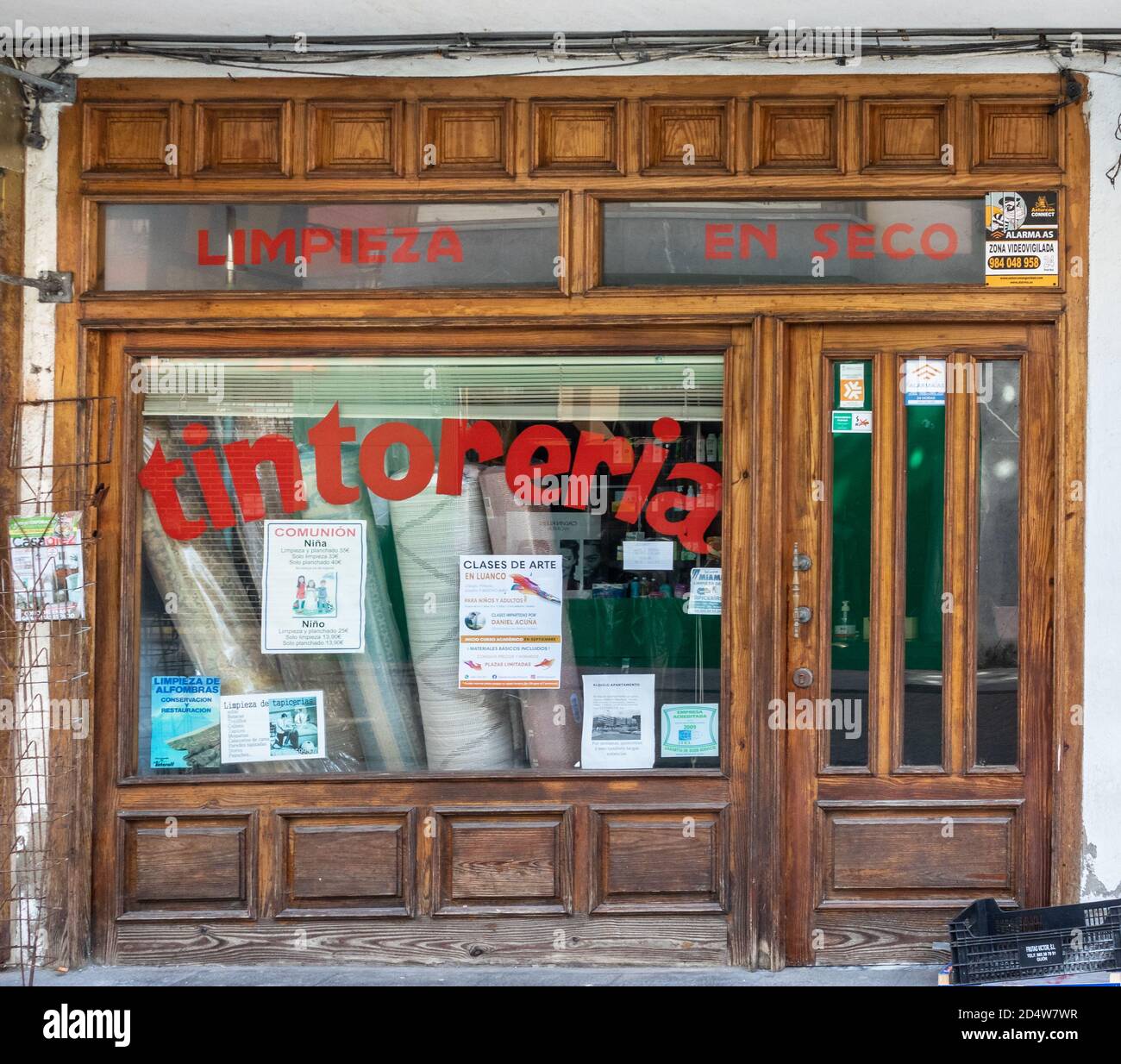 Spain; Sept 2020: Exterior of a dry cleaning store. Old wooden door and  windows. Traditional shop with red letters on the glass. Words in Spanish " Dry Stock Photo - Alamy