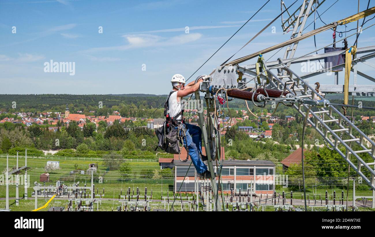 Overhead lineman & industrial climbers, working on a pylon in Bavaria, Germany Stock Photo