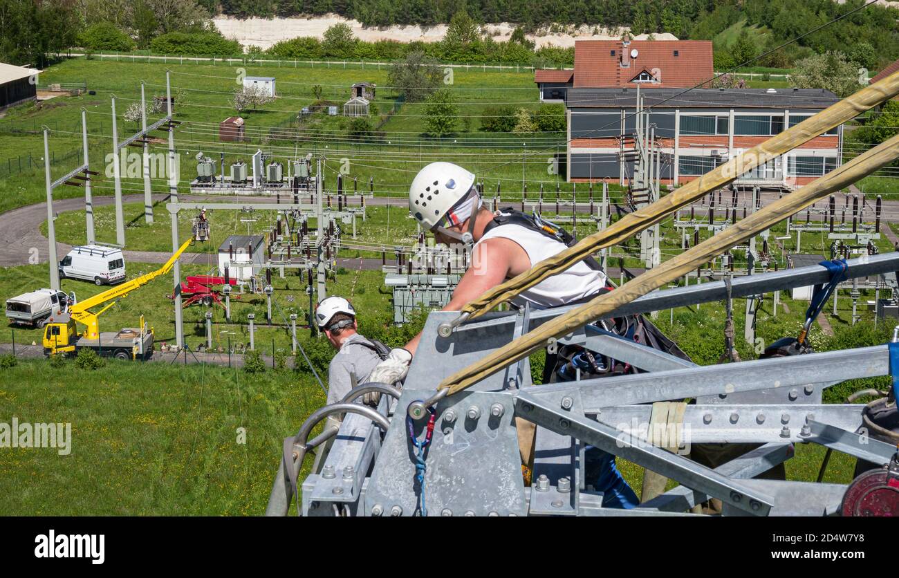 Overhead lineman & industrial climbers, working on a pylon in Bavaria, Germany Stock Photo