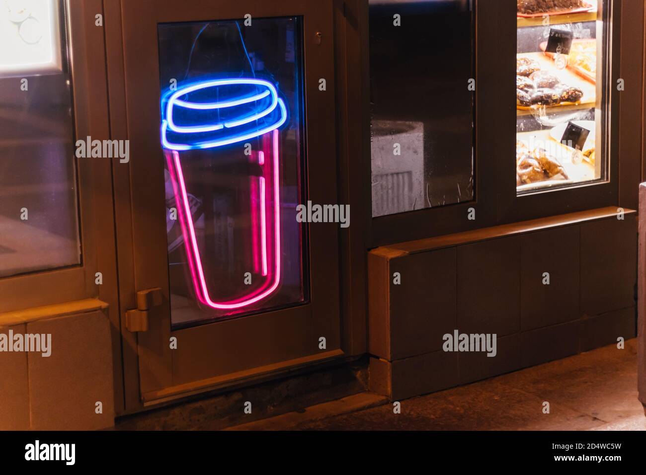 neon icon sign cup coffee glows on the window of the coffee shop at night Stock Photo