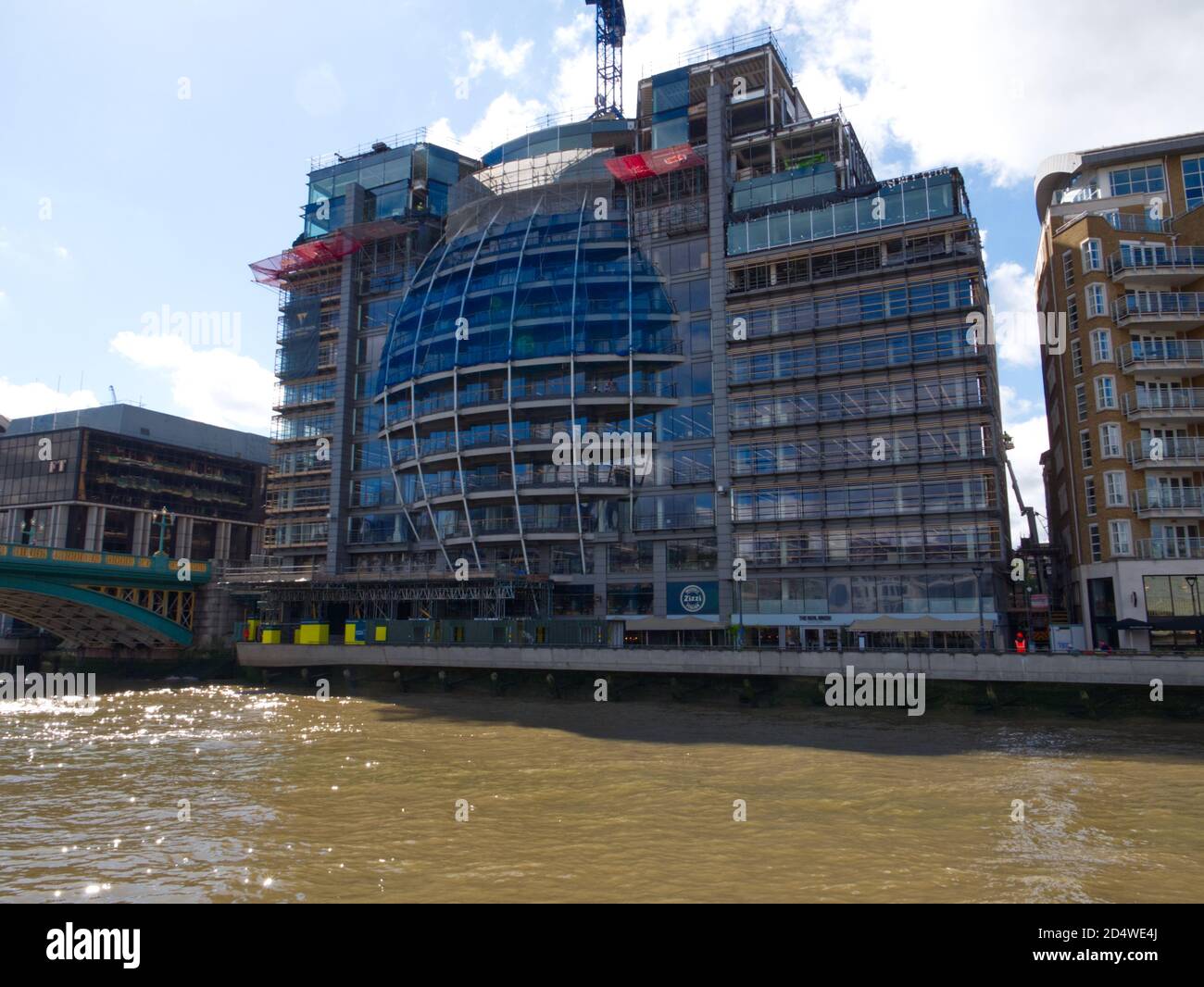 Southwark Bridge used in Harry Potter films. Steel arched Bridge Architecture. Dome fronted glass development offices, residential, shops & restaurant Stock Photo