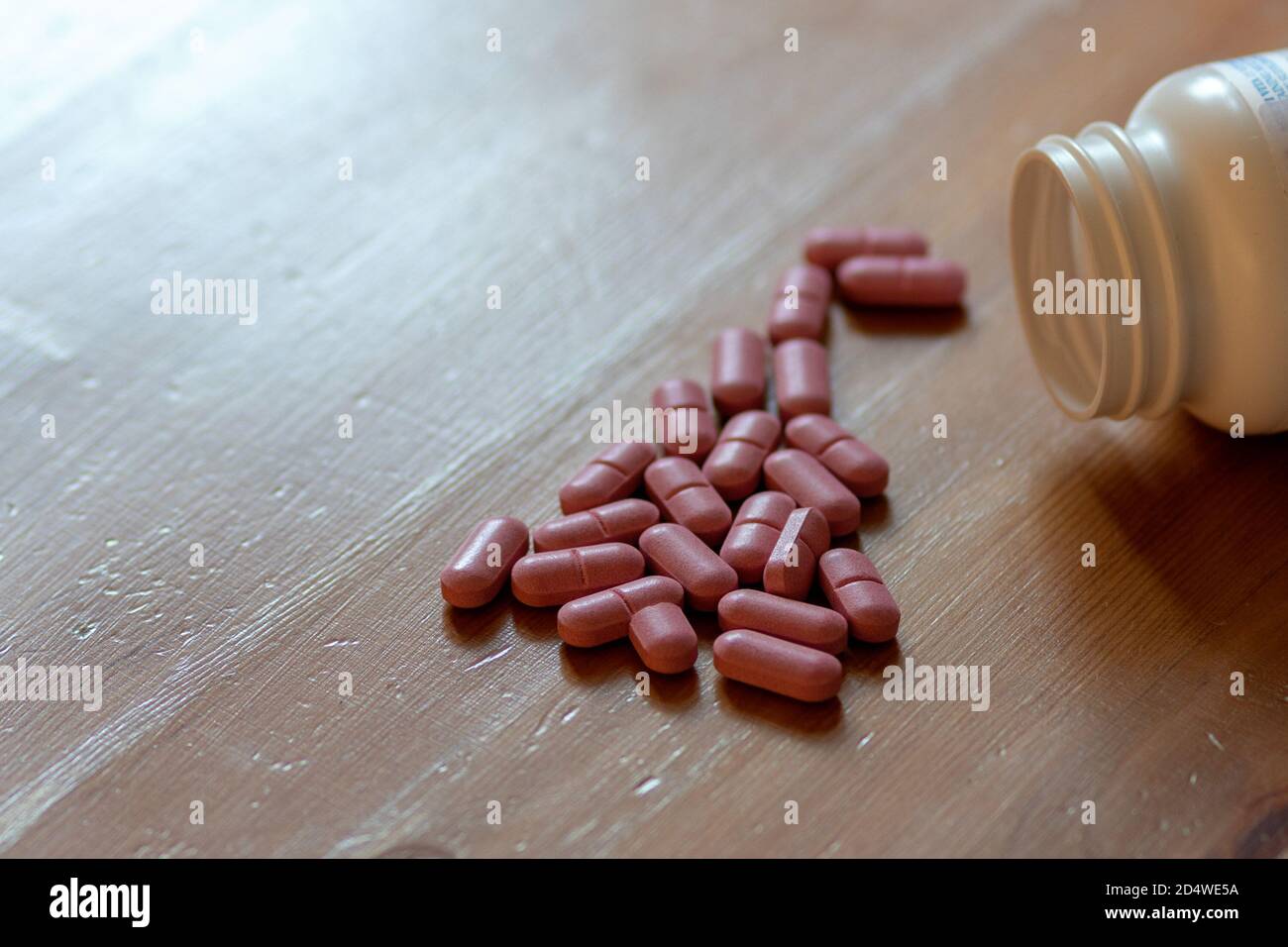 red multivitamin pills on a wooden table Stock Photo